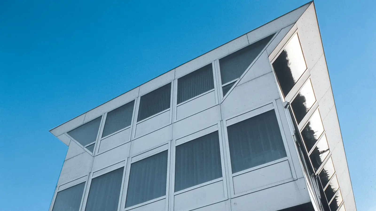 Cerramiento de un edificio contemporáneo resuelto con perfilería fina de aluminio y grandes paños de vidrio